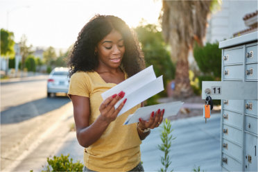 Consumer grabbing mail from box